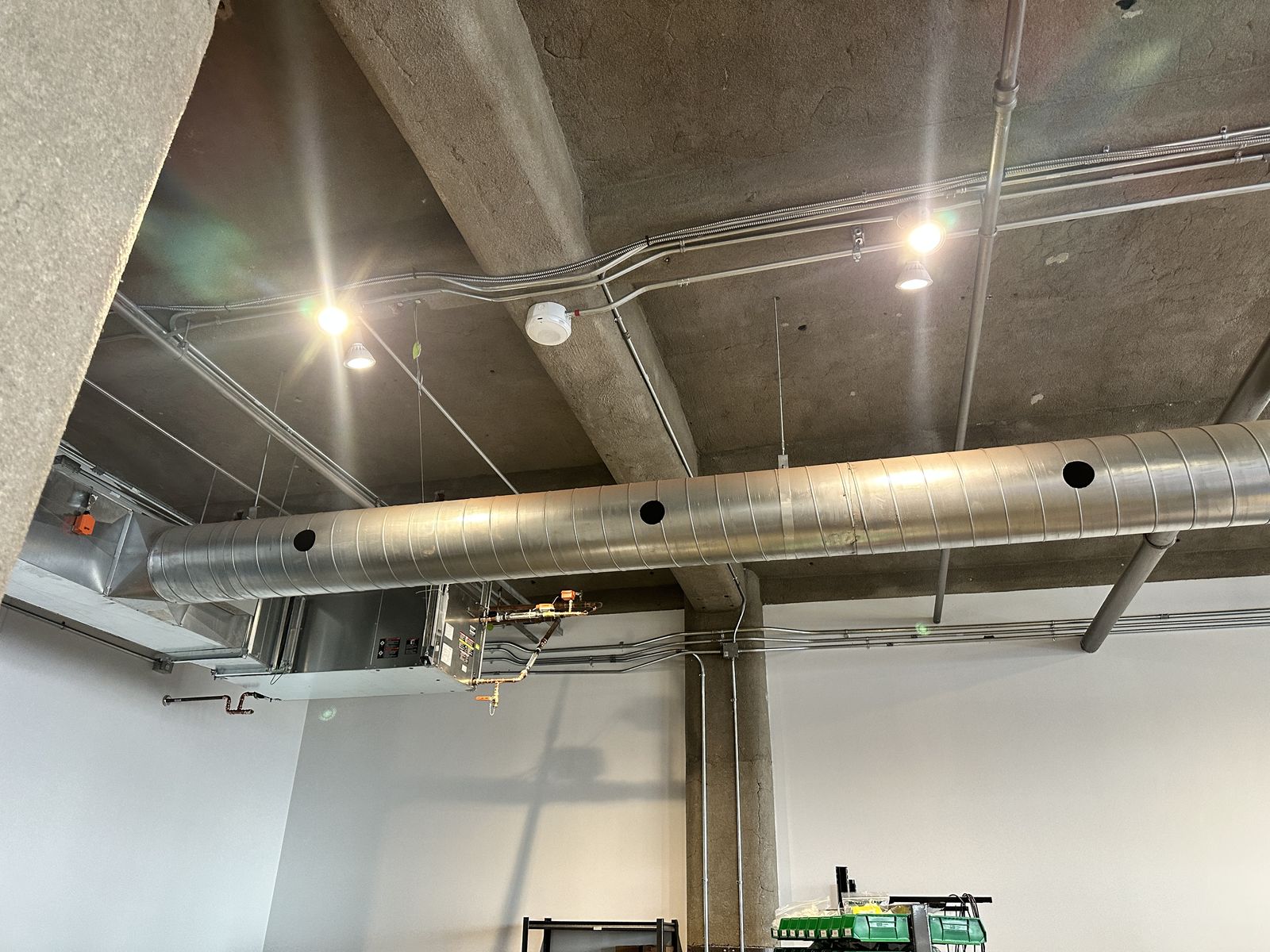 Nouveaux luminaires DEL encastrés au plafond d'une pièce aux murs de béton