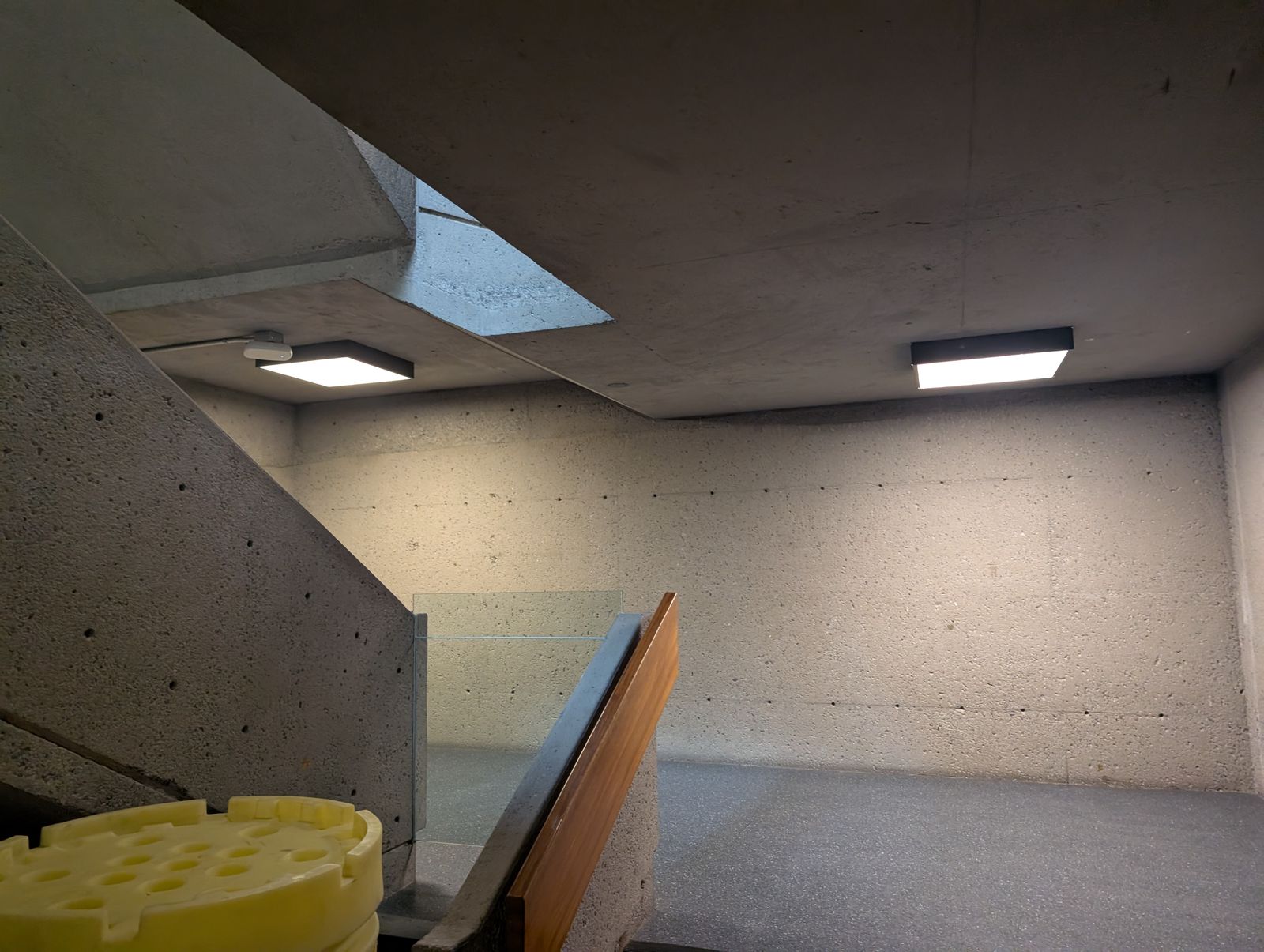 Luminaires DEL carrés et conduit en surface sur un plafond de béton