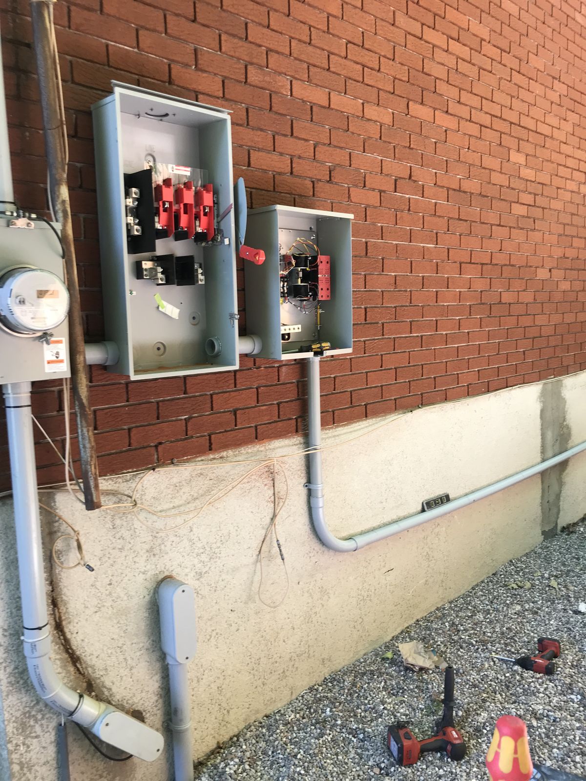 Un compteur et des sectionneurs câblés sur un mur de brique lors d’une installation de génératrice